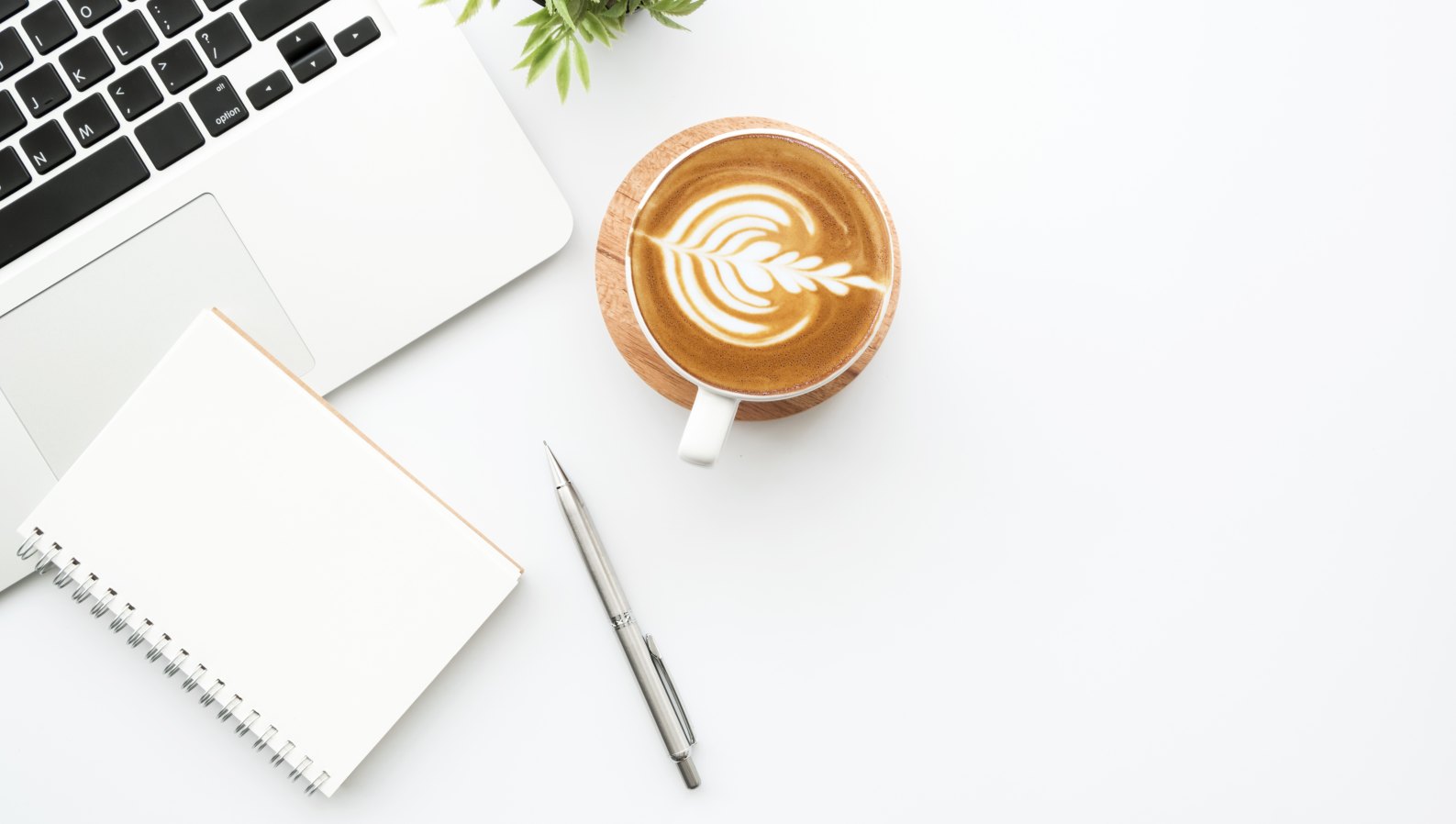 A notebook, pen, coffee and laptop on a table for planning home care questions