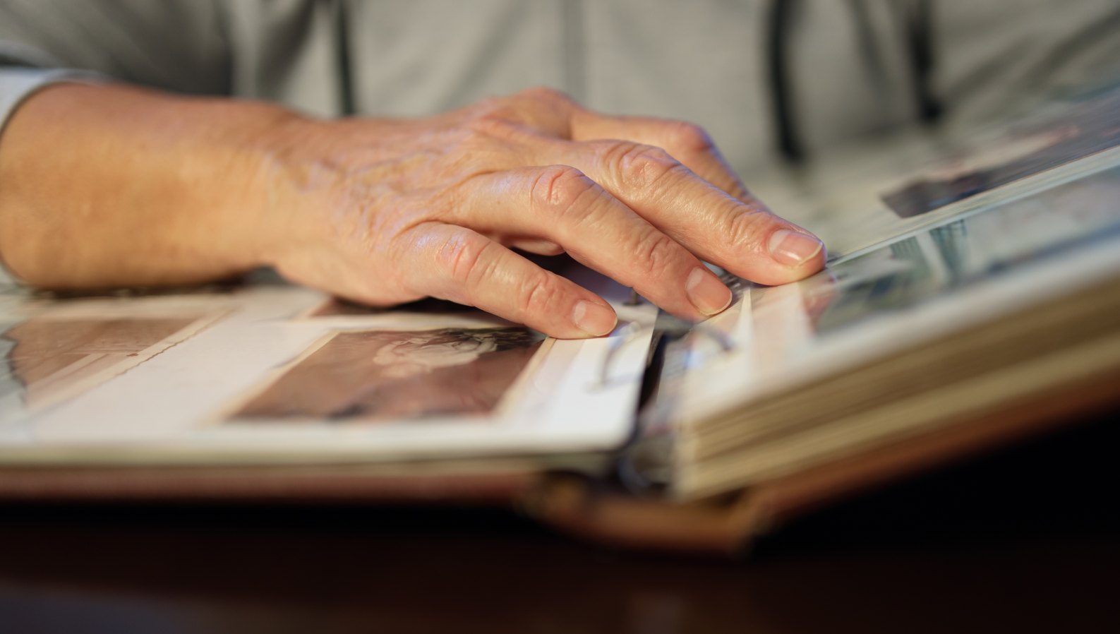An older woman looking through a family photo album, reminiscing