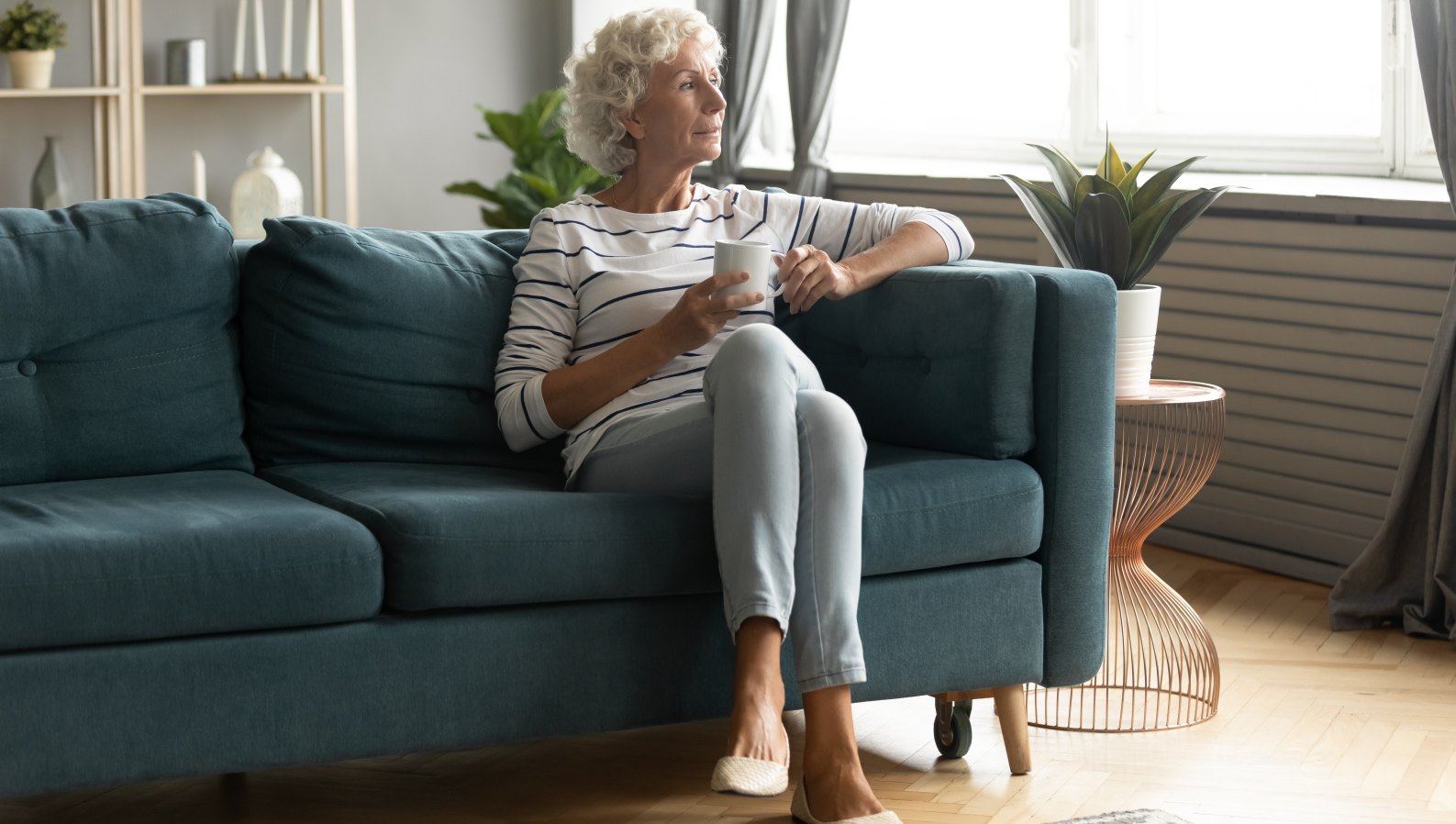 A calm senior enjoying tea in a familiar, comfortable home